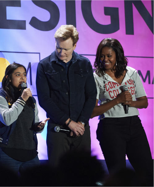 A student on stage with Conan O'Brien and Michelle Obama