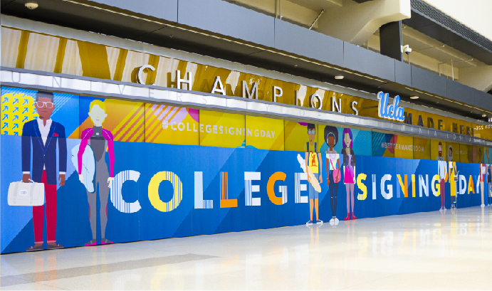 Signage of student illustrations and College Signing Day logo in the concourse