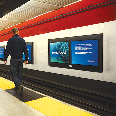 Poster of an underwater diver and school of fish with the words Public School on a BART platform